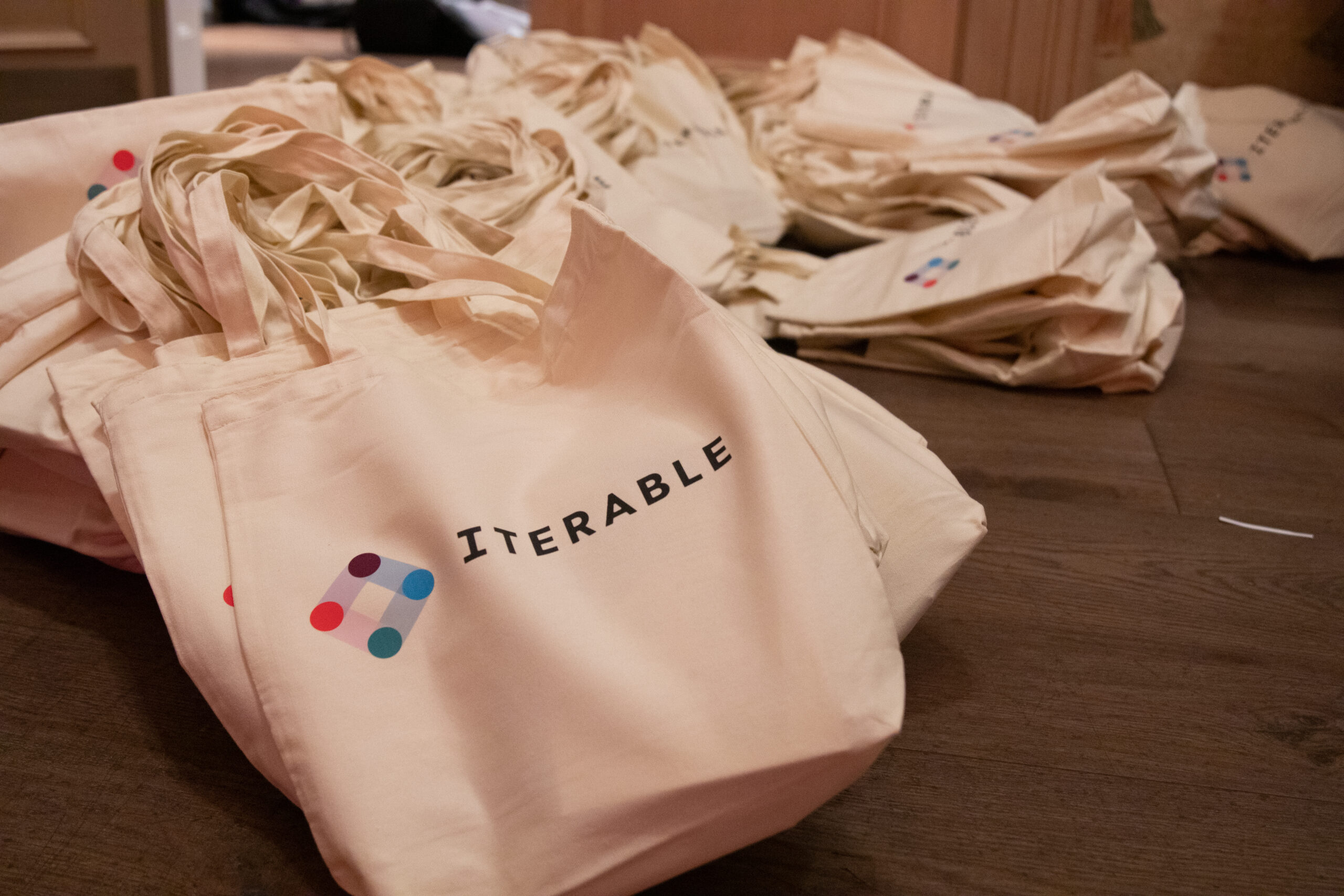 Tote bags with the iterable logo organized on a swag table