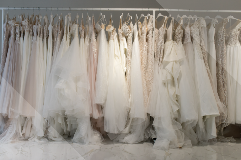 A photo of a clothing rack with wedding dresses hanging from it.
